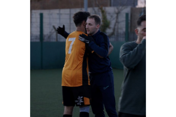 Dan hugs a participant in a football session he is coaching