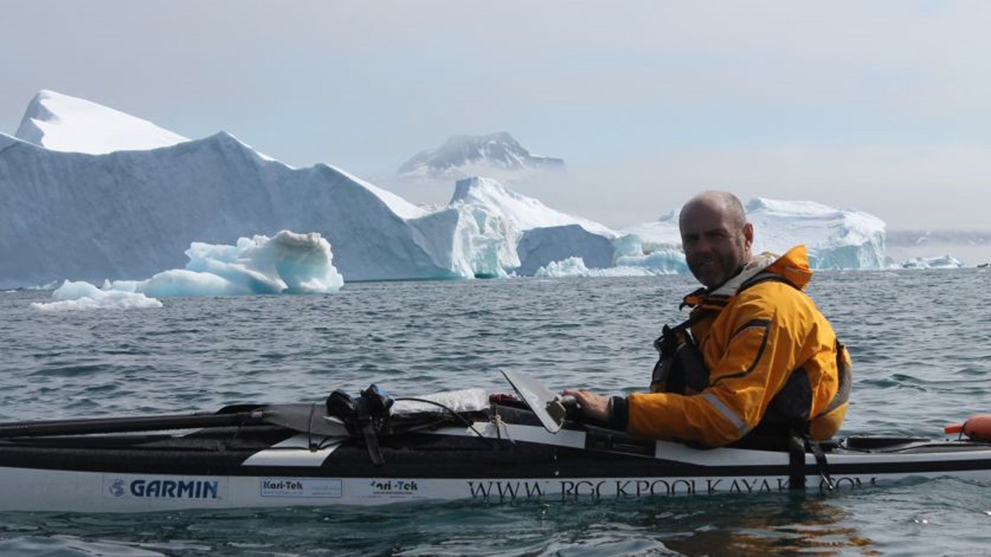 man in canoe near glaciers