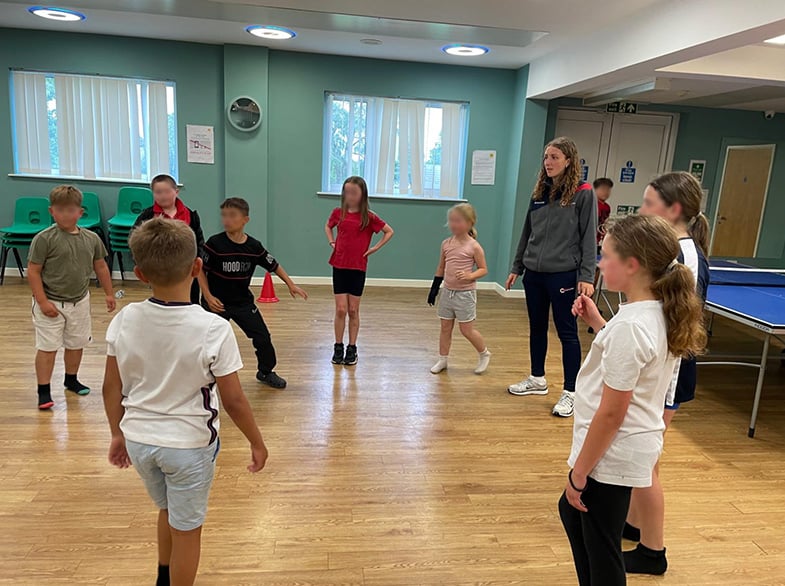 A group of children being coached in a village hall