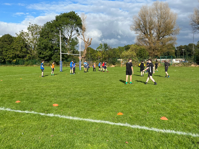 Students participating in rugby training on a pitch