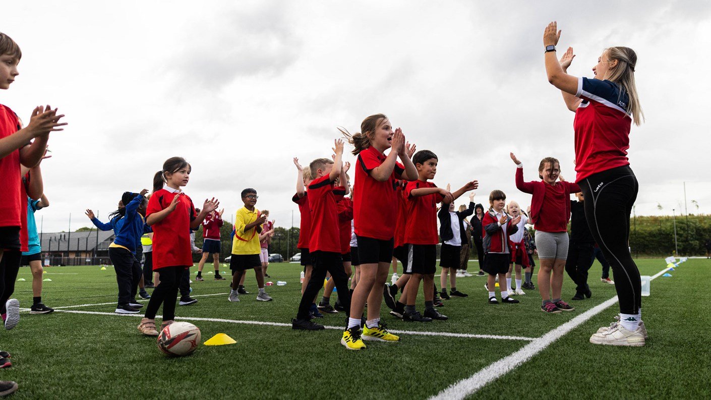 children on playing field with coach