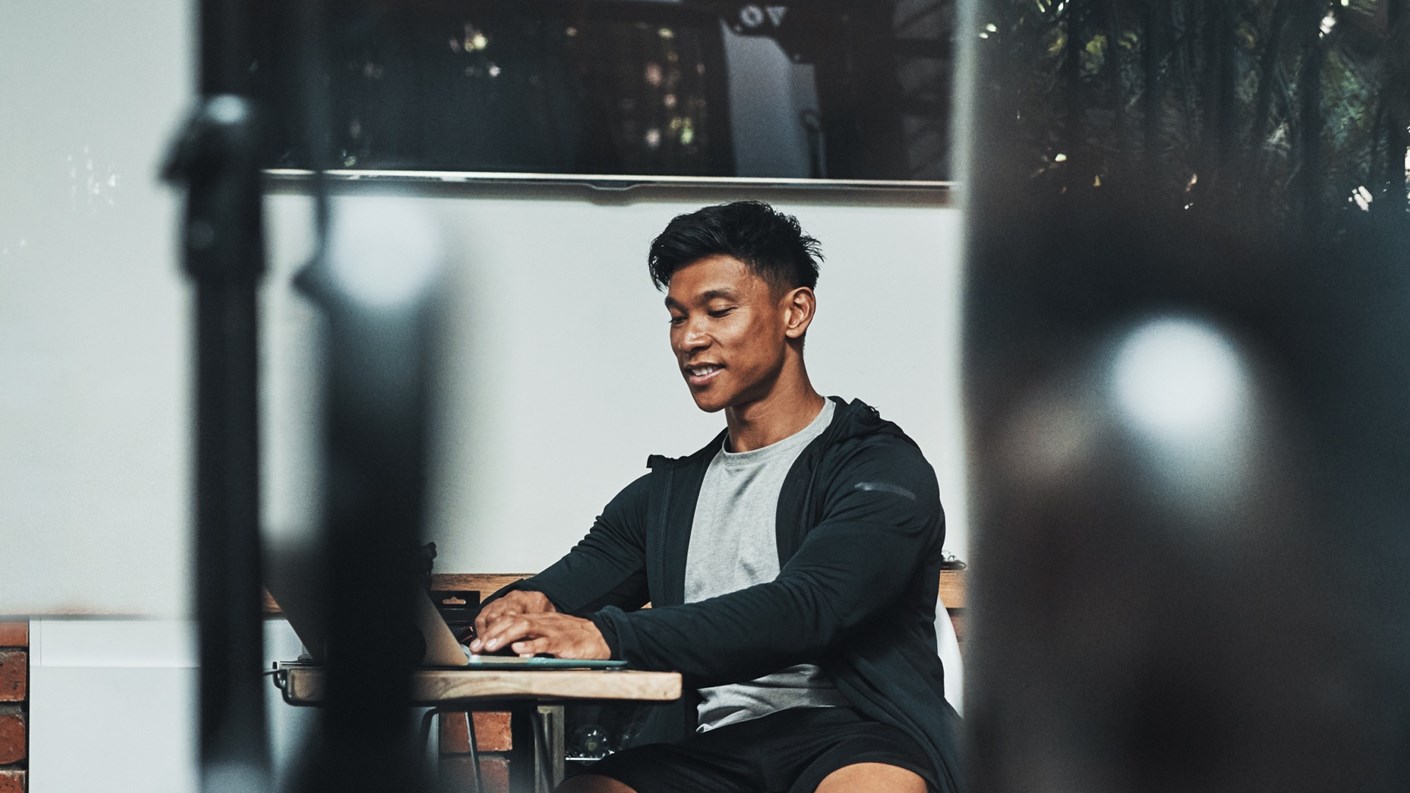 Man in sportswear working on laptop