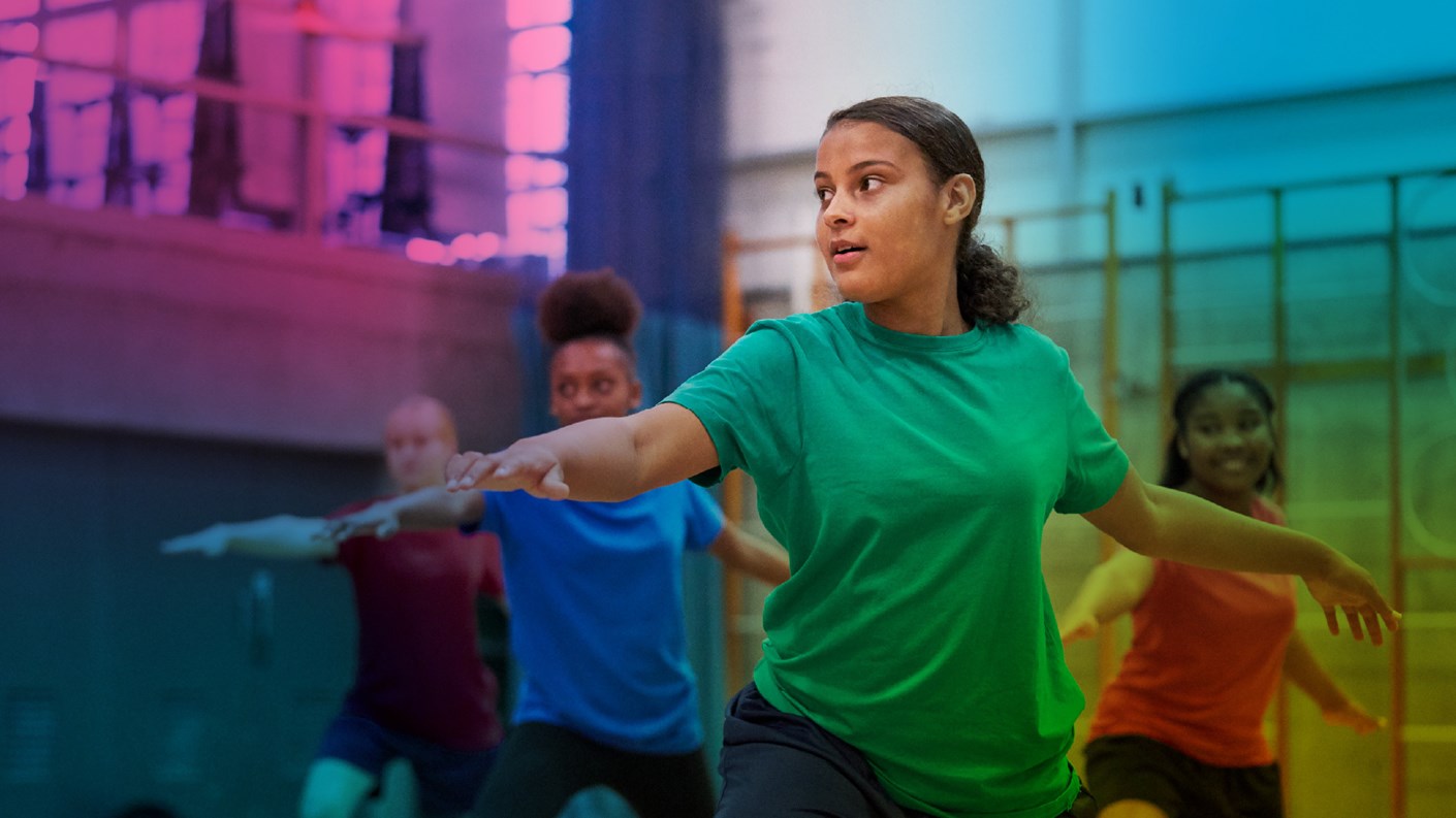 Teenage girls exercising in school sports hall