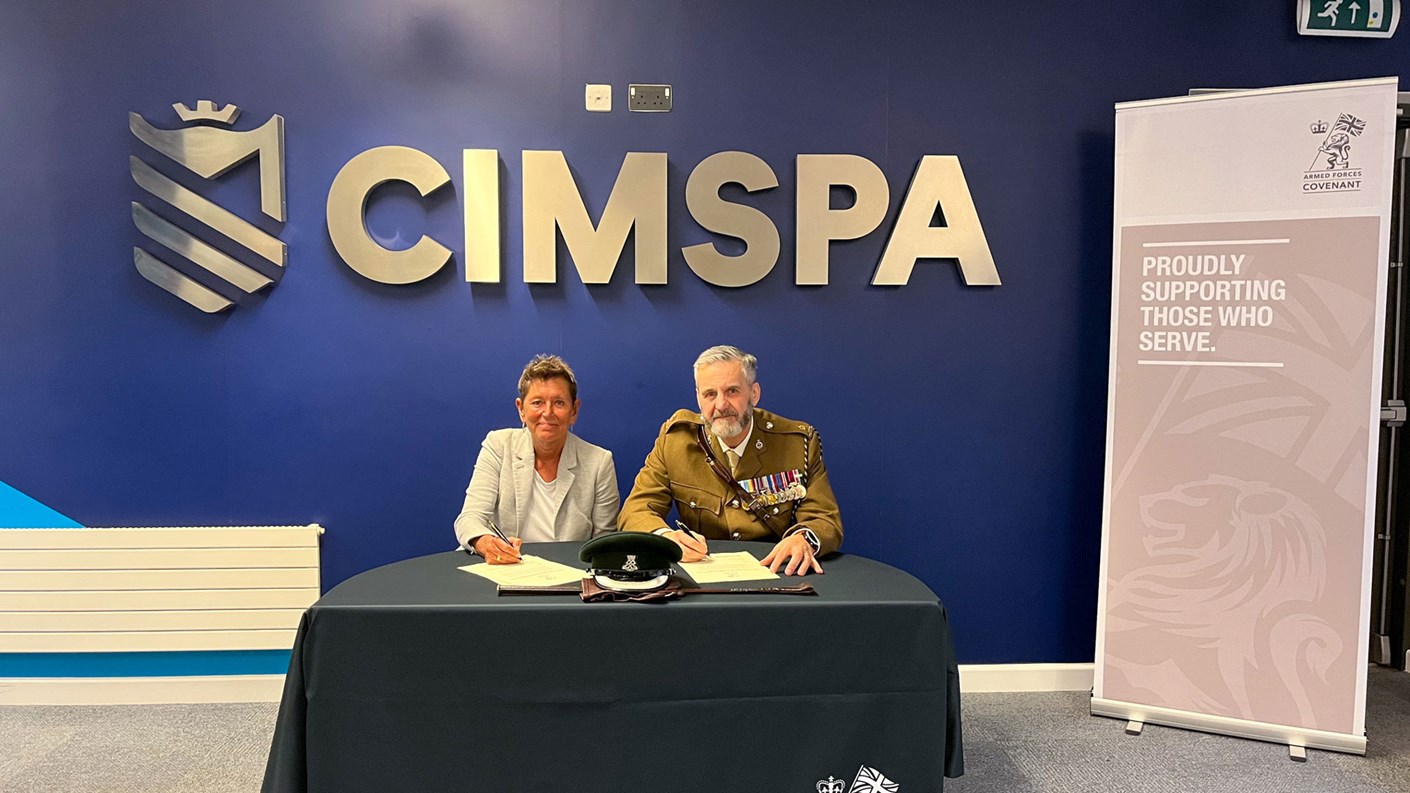two people sat at desk signing document
