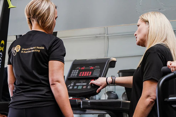 Woman on treadmill with personal trainer