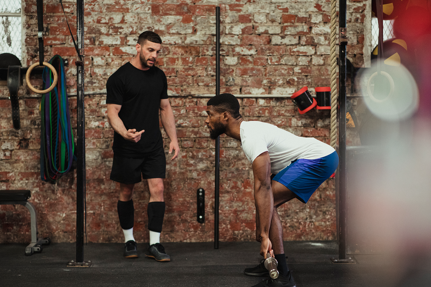 A personal trainer directing a person on correct weight lifting posture