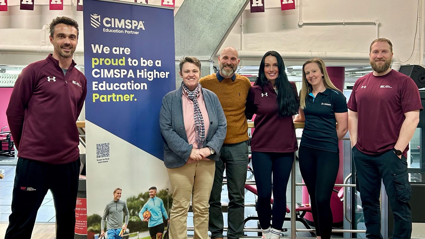 group of six people standing with cimspa banner