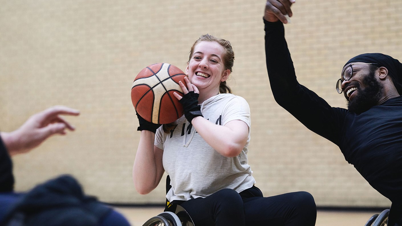 woman in wheelchair throwing basketball