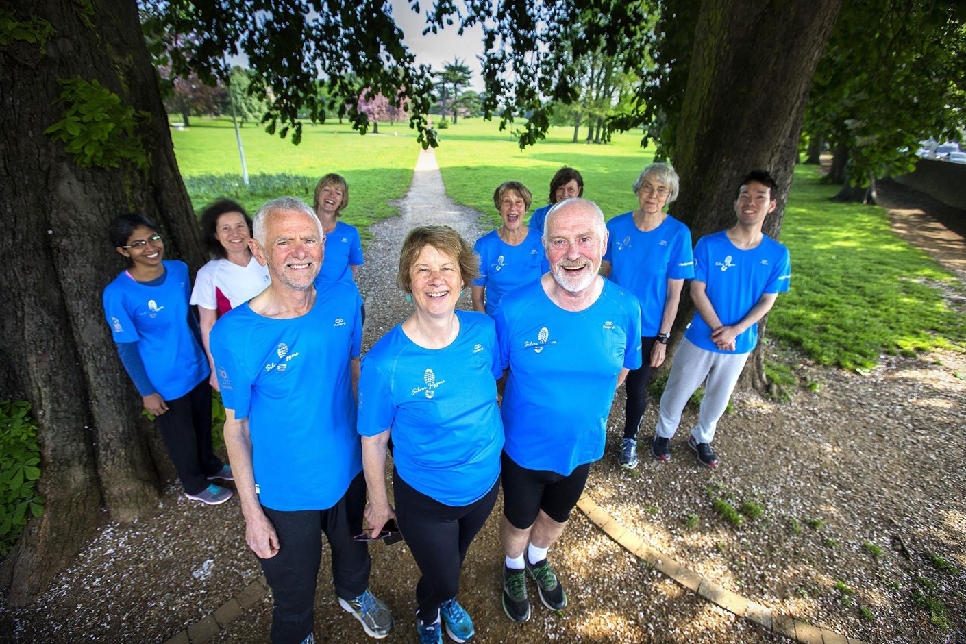group of older joggers standing in park
