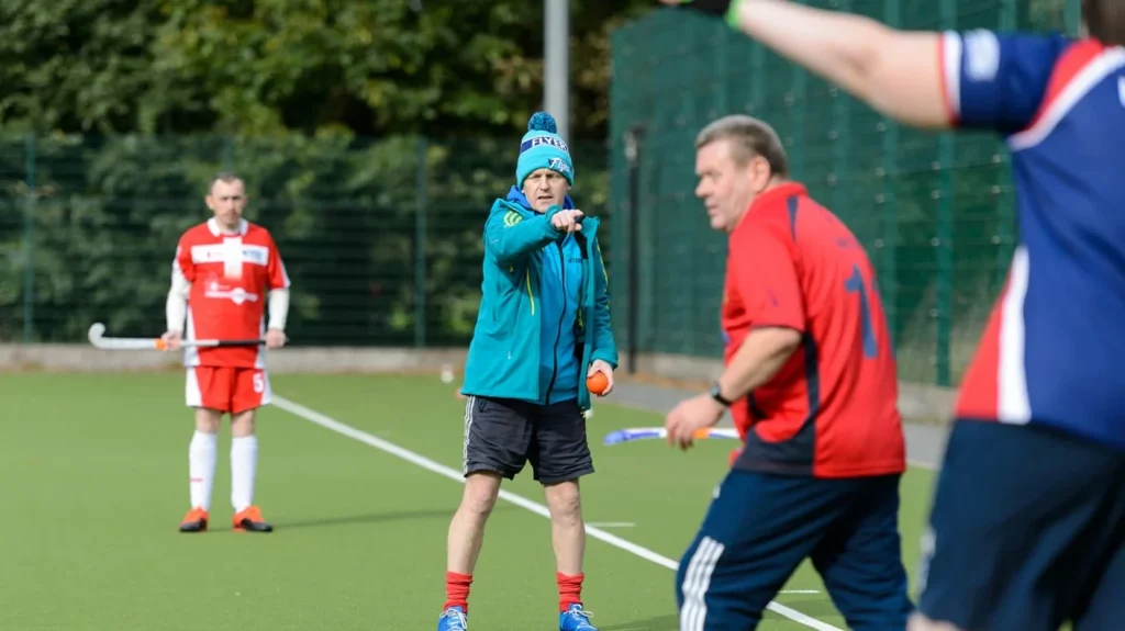 Football coach pointing to player, providing instructions