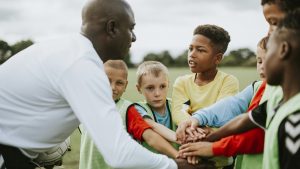 Junior football team stacking hands before a match